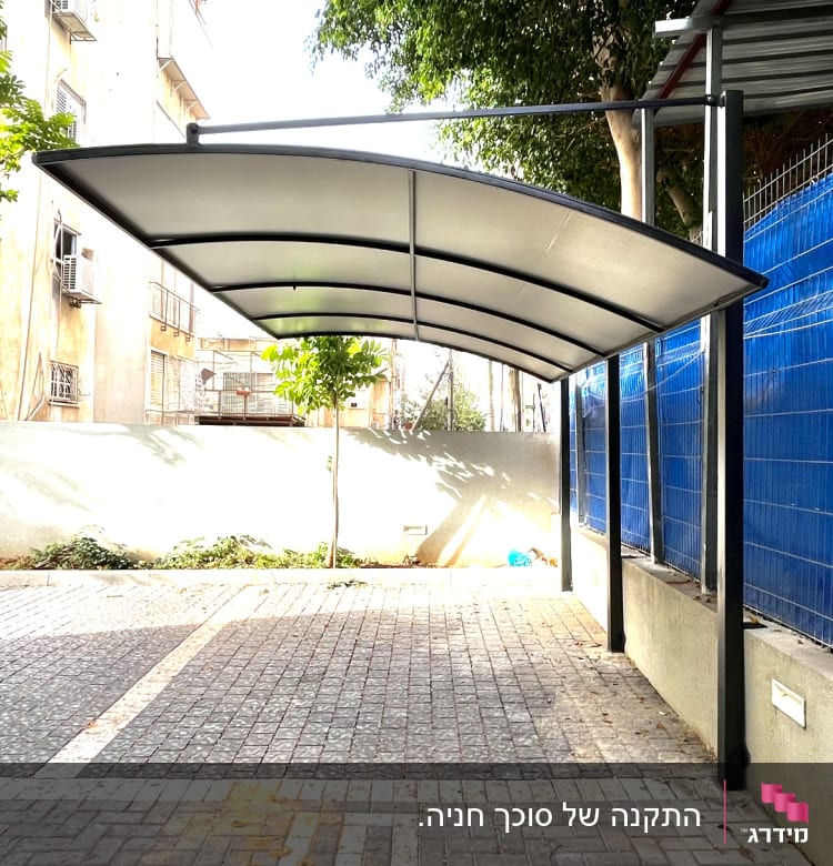 סככה מתכתית עם גג קמור מעל שביל מרוצף